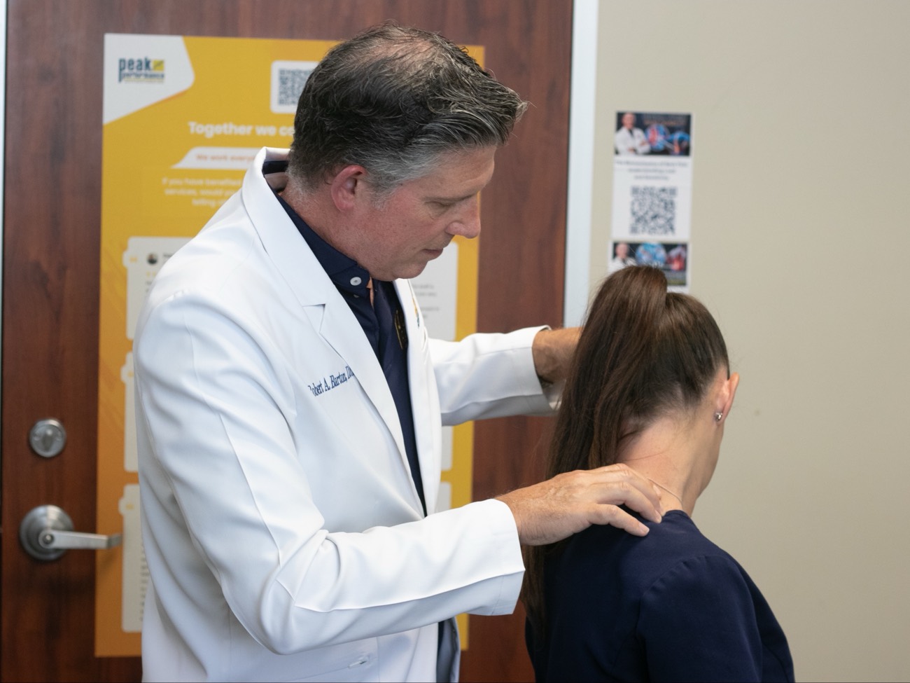 Dr. Barton performing a hands-on neck exam in the consult room