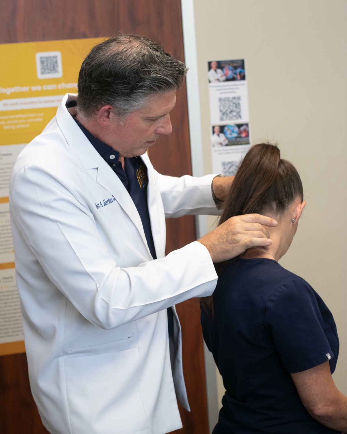 Dr. Barton performing a gentle neck loading exam on a patient in the consult room